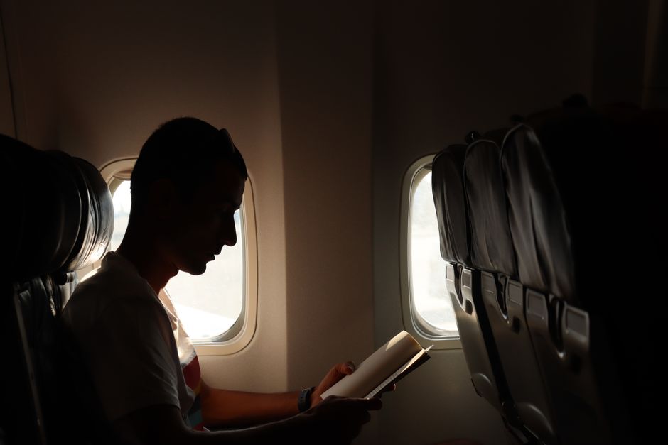 person reading a book on an airplane
