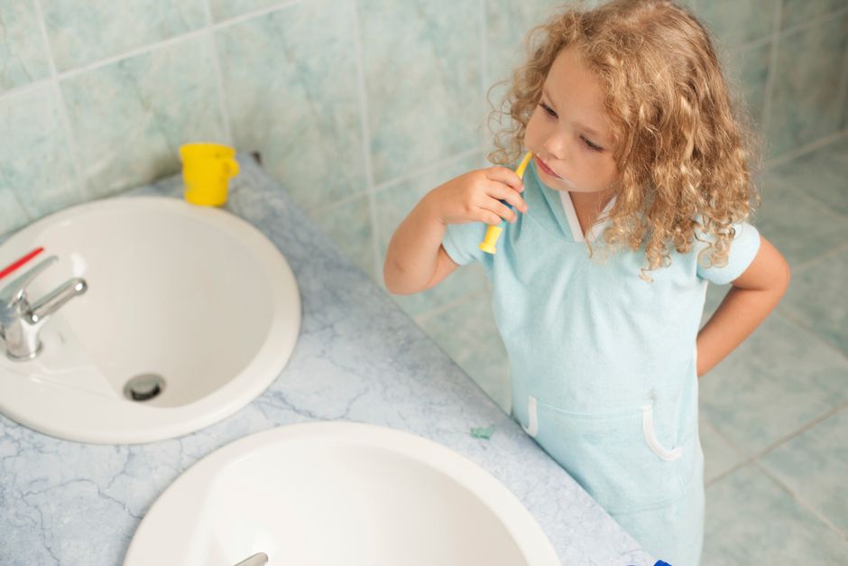 child brushing teeth in bathroom